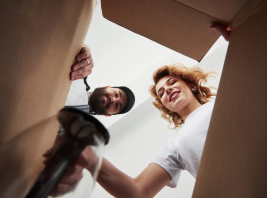 Två personer som tittar ner i en flyttlåda