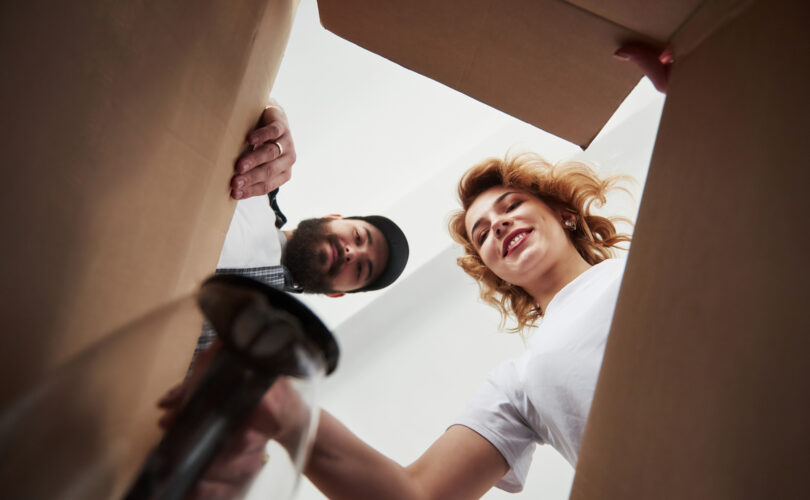 Två personer som tittar ner i en flyttlåda